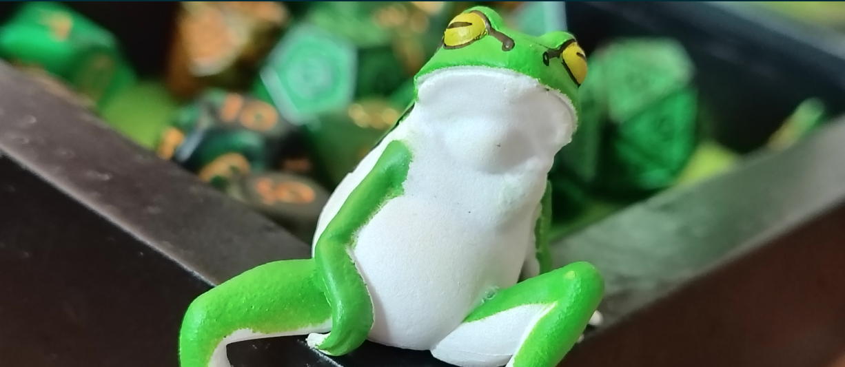 Frog figurine with some dice